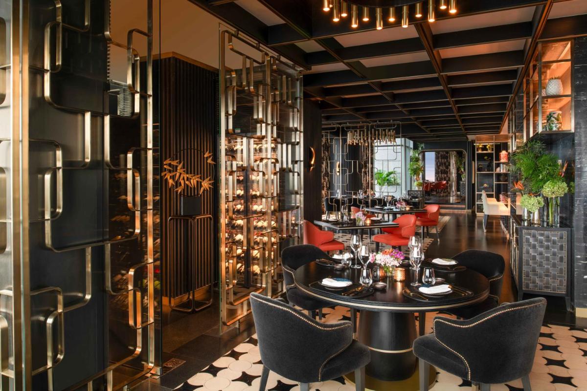 a restaurant with a table and chairs in a room at Four Seasons Hotel Bengaluru at Embassy ONE in Bengaluru a restaurant with a table and chairs in a room at Four Seasons Hotel Bengaluru at Embassy ONE in Bengaluru