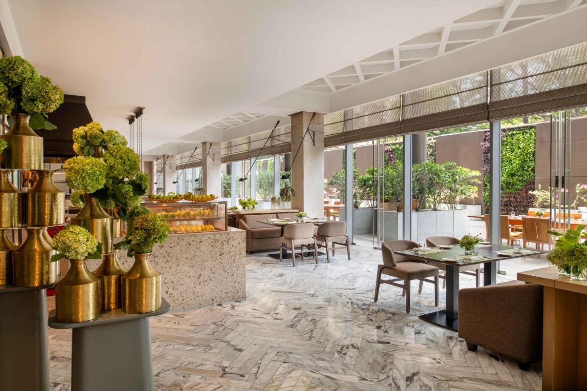 a rendering of a restaurant with tables and chairs at Four Seasons Hotel Bengaluru at Embassy ONE in Bengaluru a rendering of a restaurant with tables and chairs at Four Seasons Hotel Bengaluru at Embassy ONE in Bengaluru