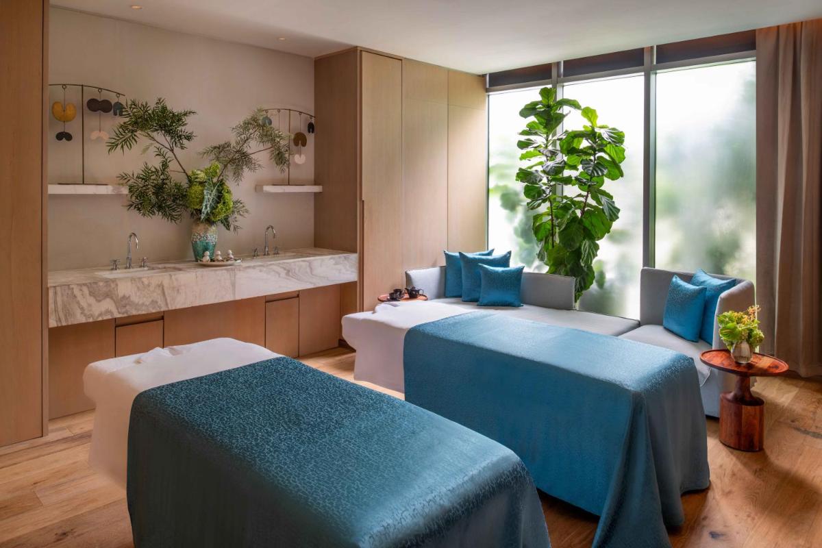 a bedroom with two beds and a sink and a window at Four Seasons Hotel Bengaluru at Embassy ONE in Bengaluru a bedroom with two beds and a sink and a window at Four Seasons Hotel Bengaluru at Embassy ONE in Bengaluru