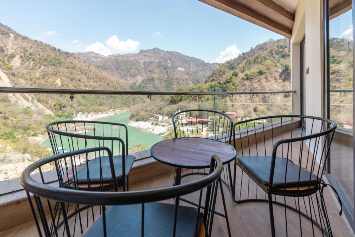 a balcony with three chairs and a table with a view at Antalya By Divine Ganga Cottage in Rishīkesh
