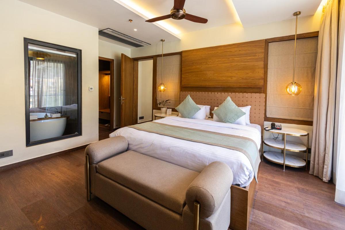 a bedroom with a large bed and a bathroom at Antalya By Divine Ganga Cottage in Rishīkesh