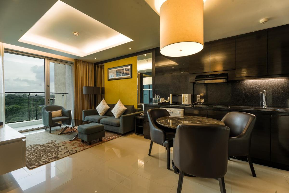 a kitchen and living room with a table and chairs at DoubleTree Suites by Hilton Bengaluru Outer Ring Road in Bengaluru