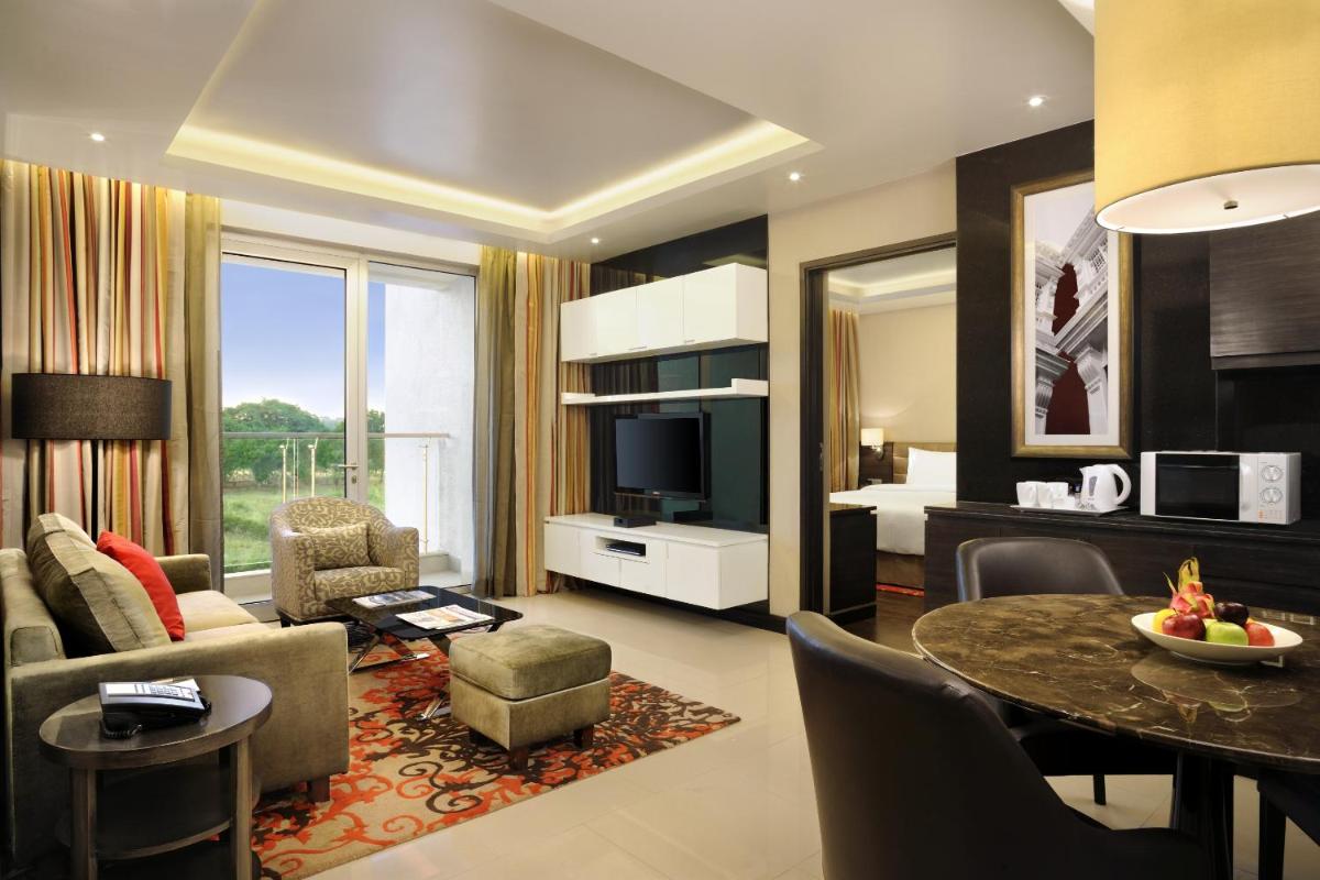 a living room with a couch and a table in a room at DoubleTree Suites by Hilton Bengaluru Outer Ring Road in Bengaluru