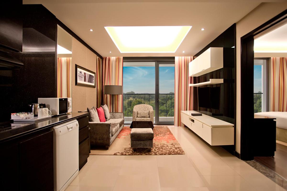 a large living room with a television and a couch at DoubleTree Suites by Hilton Bengaluru Outer Ring Road in Bengaluru