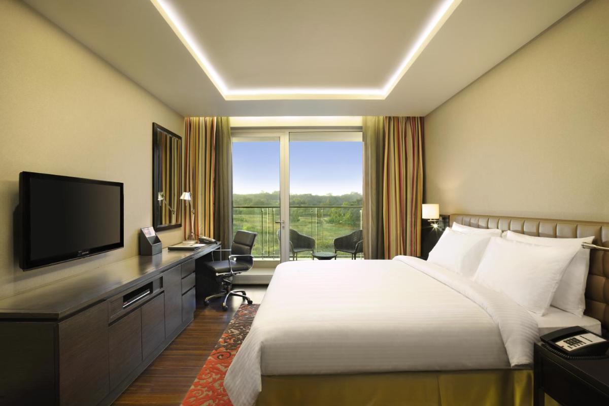 a hotel room with a bed and a large window at DoubleTree Suites by Hilton Bengaluru Outer Ring Road in Bengaluru