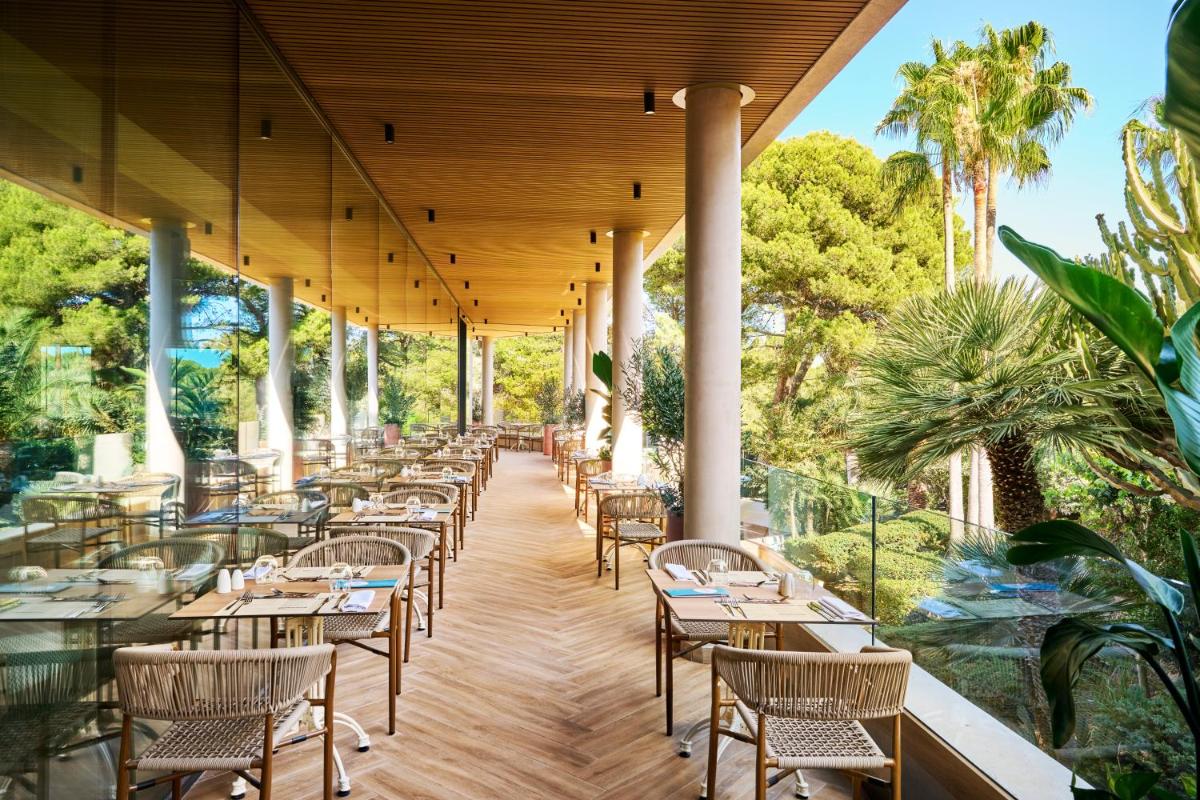 una fila de mesas y sillas en un patio en Grupotel Cala Marsal Nature Hotel - New Reopening 2025, en Portocolom