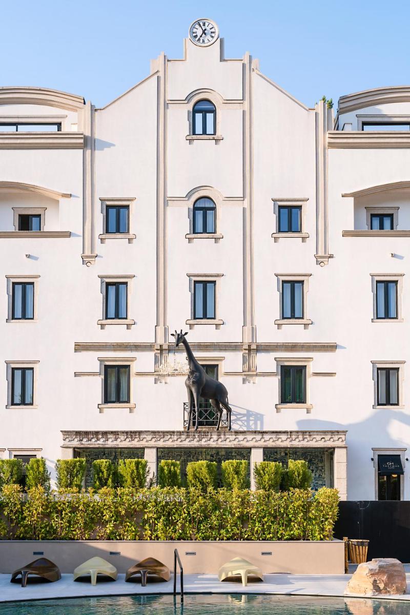 uma estátua de uma girafa em frente a um edifício em Grande Hotel Thermas Nature & SPA nas Termas de São Pedro do Sul