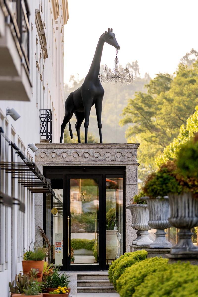 uma estátua de uma girafa no topo de um prédio em Grande Hotel Thermas Nature & SPA nas Termas de São Pedro do Sul