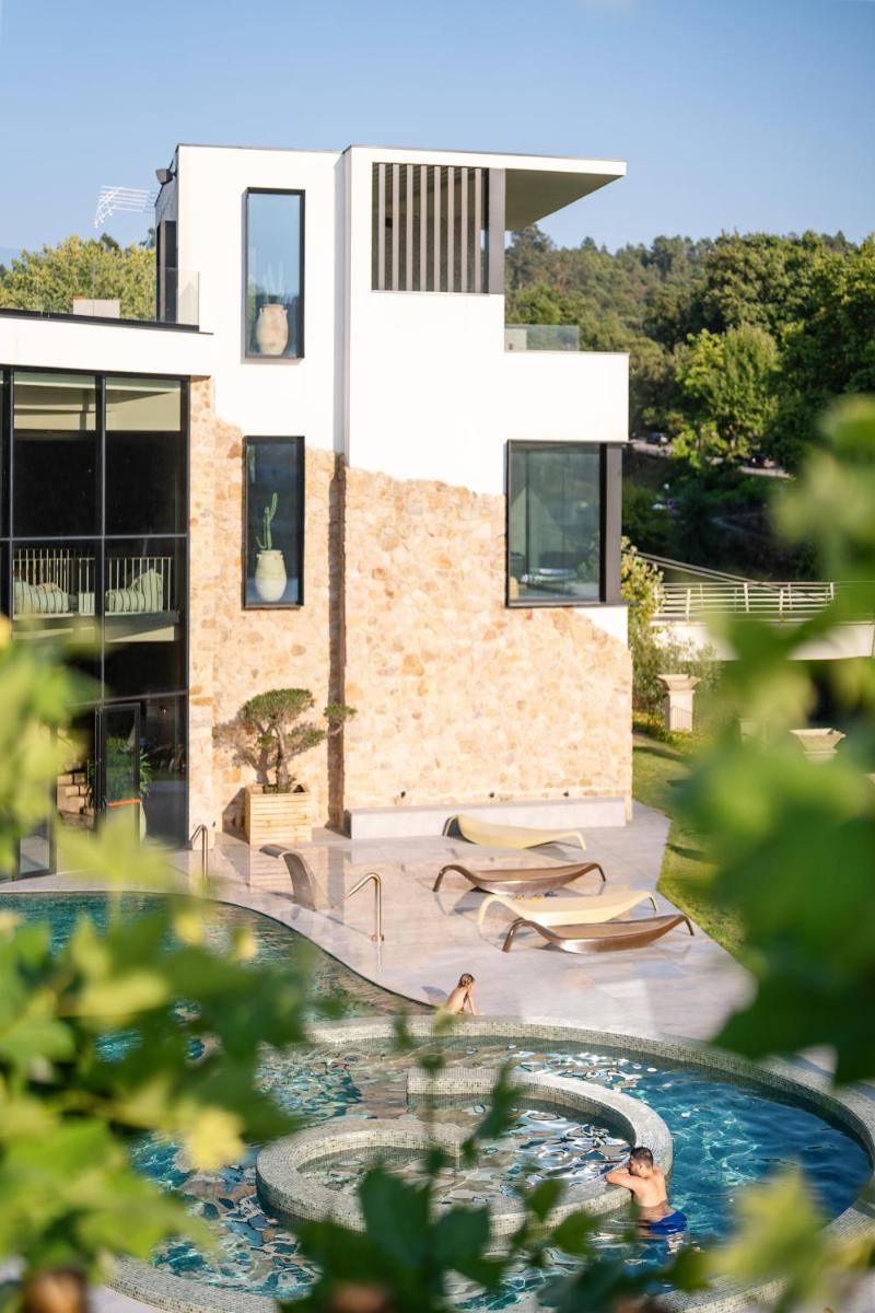 uma casa com uma piscina na frente em Grande Hotel Thermas Nature & SPA nas Termas de São Pedro do Sul mais 91 fotografias