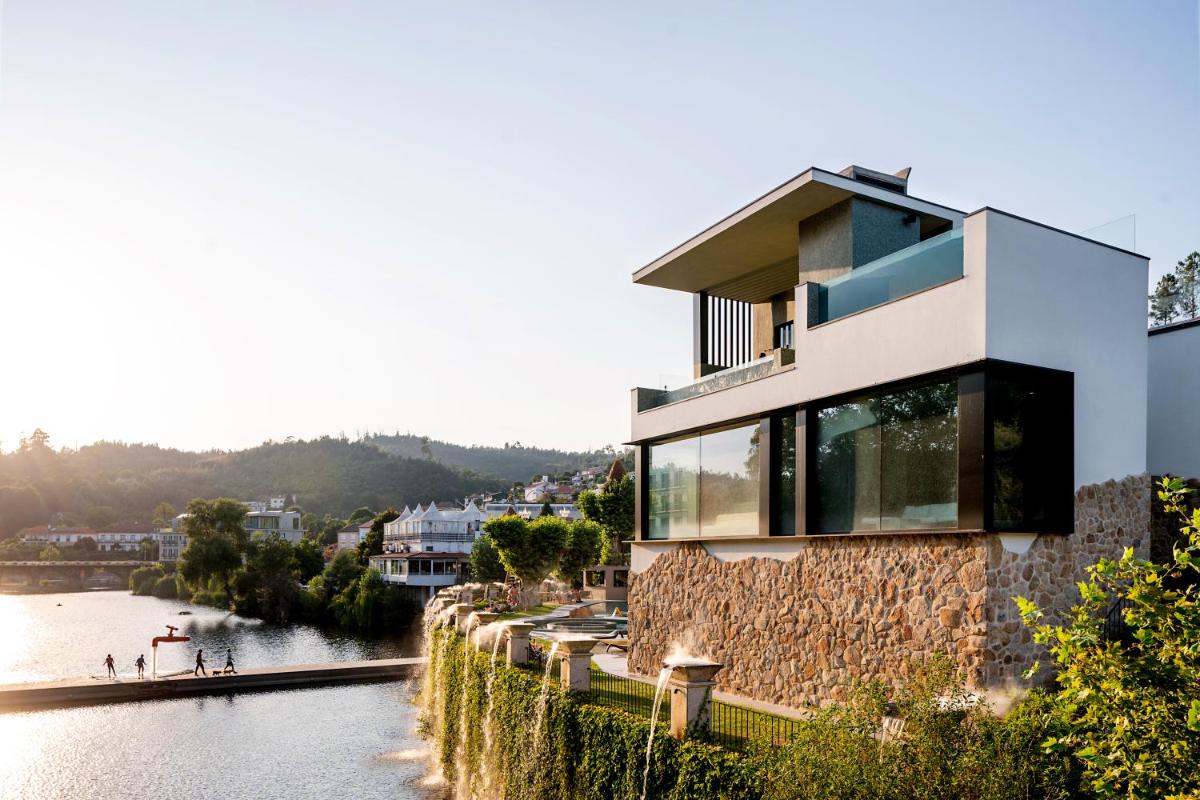 uma casa numa colina ao lado de um rio em Grande Hotel Thermas Nature & SPA nas Termas de São Pedro do Sul