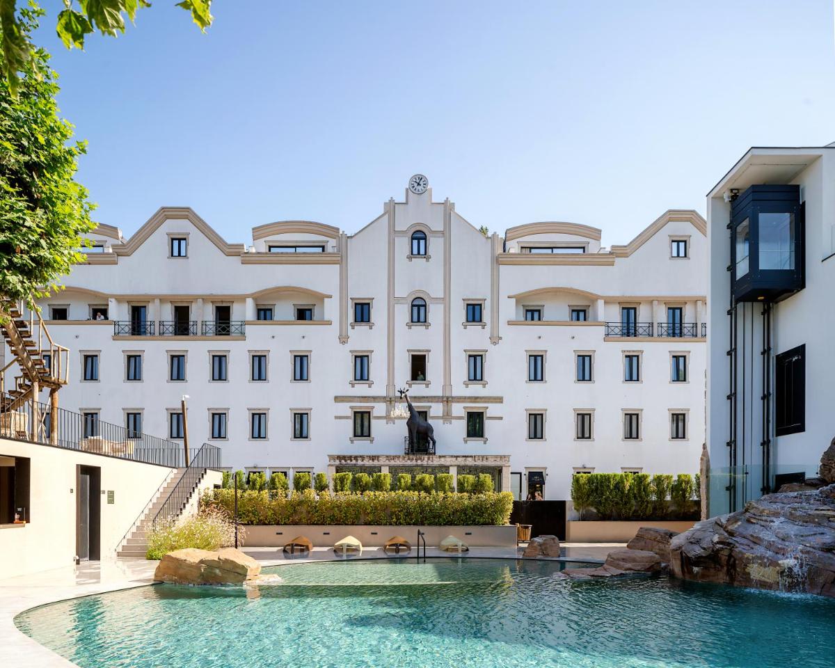 um grande edifício branco com uma piscina na frente em Grande Hotel Thermas Nature & SPA nas Termas de São Pedro do Sul