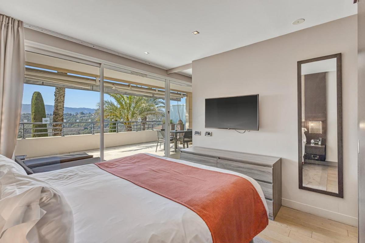 une chambre avec un grand lit et une télévision à écran plat dans l'établissement Royal Mougins Golf, Hotel & Spa de Luxe, à Mougins