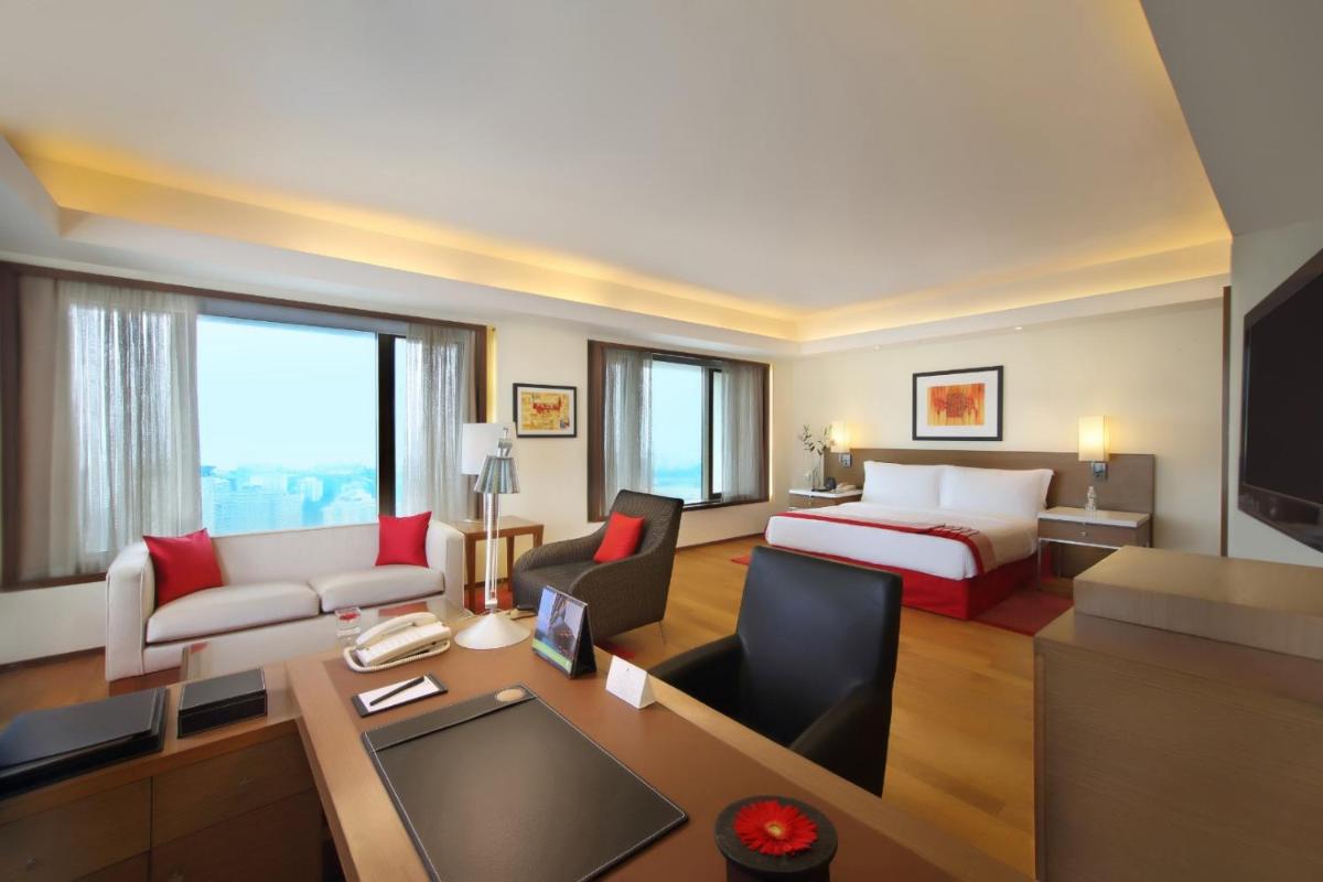 a hotel room with a bed and a living room at Trident Nariman Point in Mumbai a hotel room with a bed and a living room at Trident Nariman Point in Mumbai