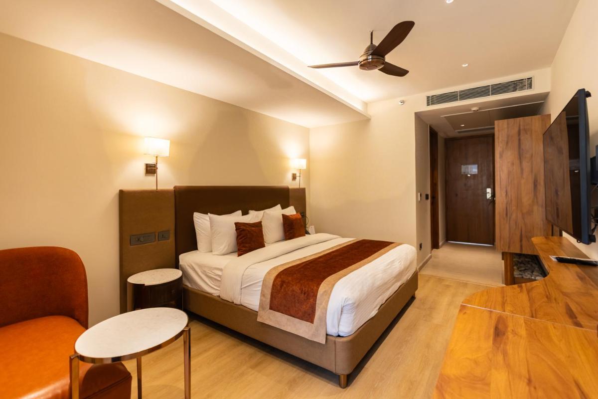 a hotel room with a bed and a couch at Antalya By Divine Ganga Cottage in Rishīkesh