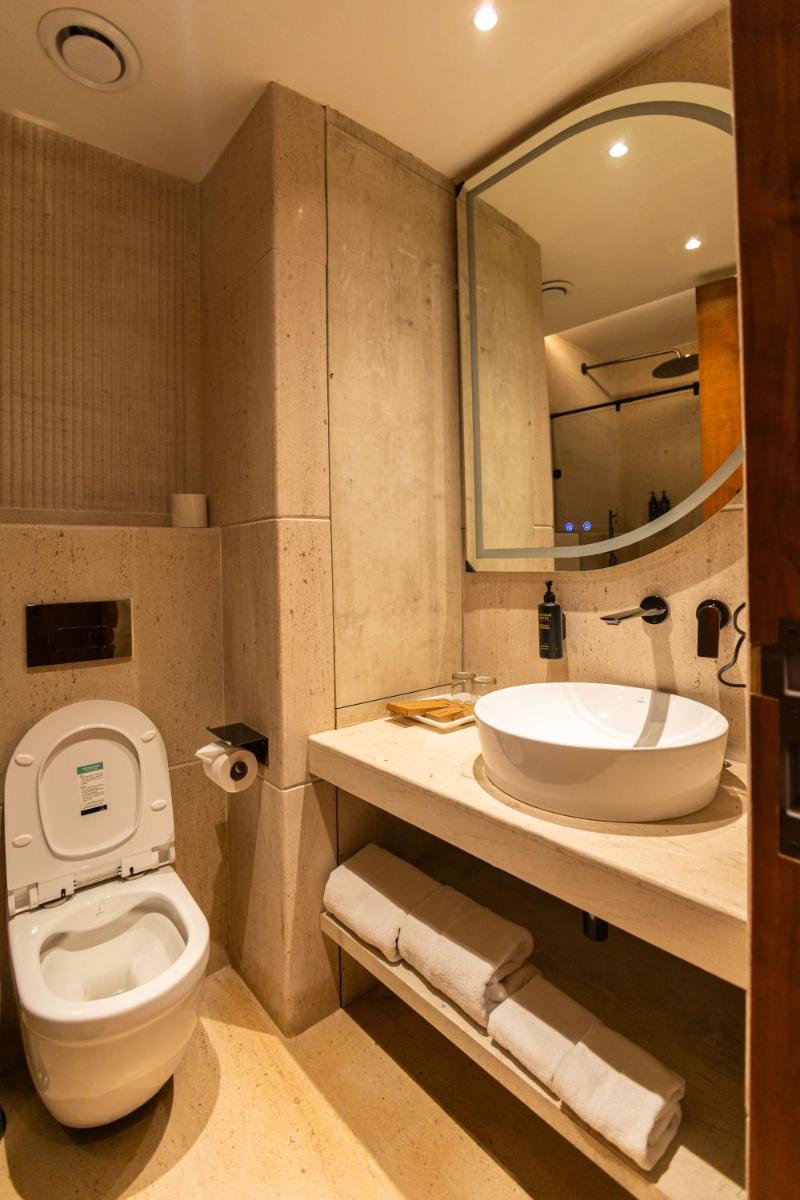 a bathroom with a toilet and a sink and a mirror at Antalya By Divine Ganga Cottage in Rishīkesh
