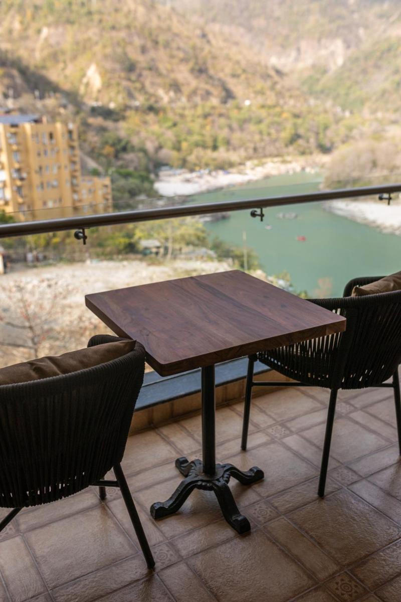 a table and two chairs on a balcony with a view at Antalya By Divine Ganga Cottage in Rishīkesh
