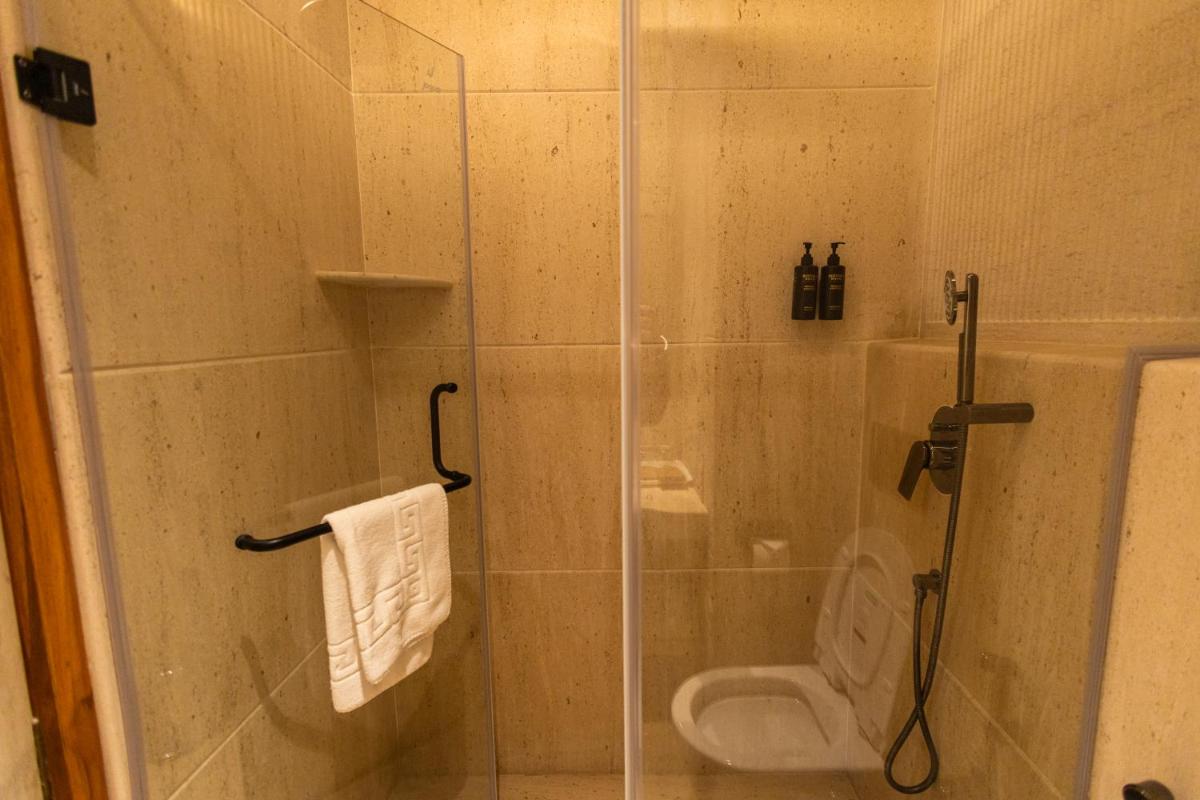 a bathroom with a glass shower with a toilet at Antalya By Divine Ganga Cottage in Rishīkesh