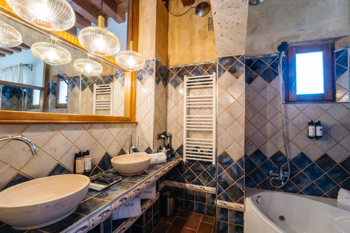 Un baño con dos lavabos, una bañera y un espejo. en Abba las Viñas Tiedra, en Tiedra