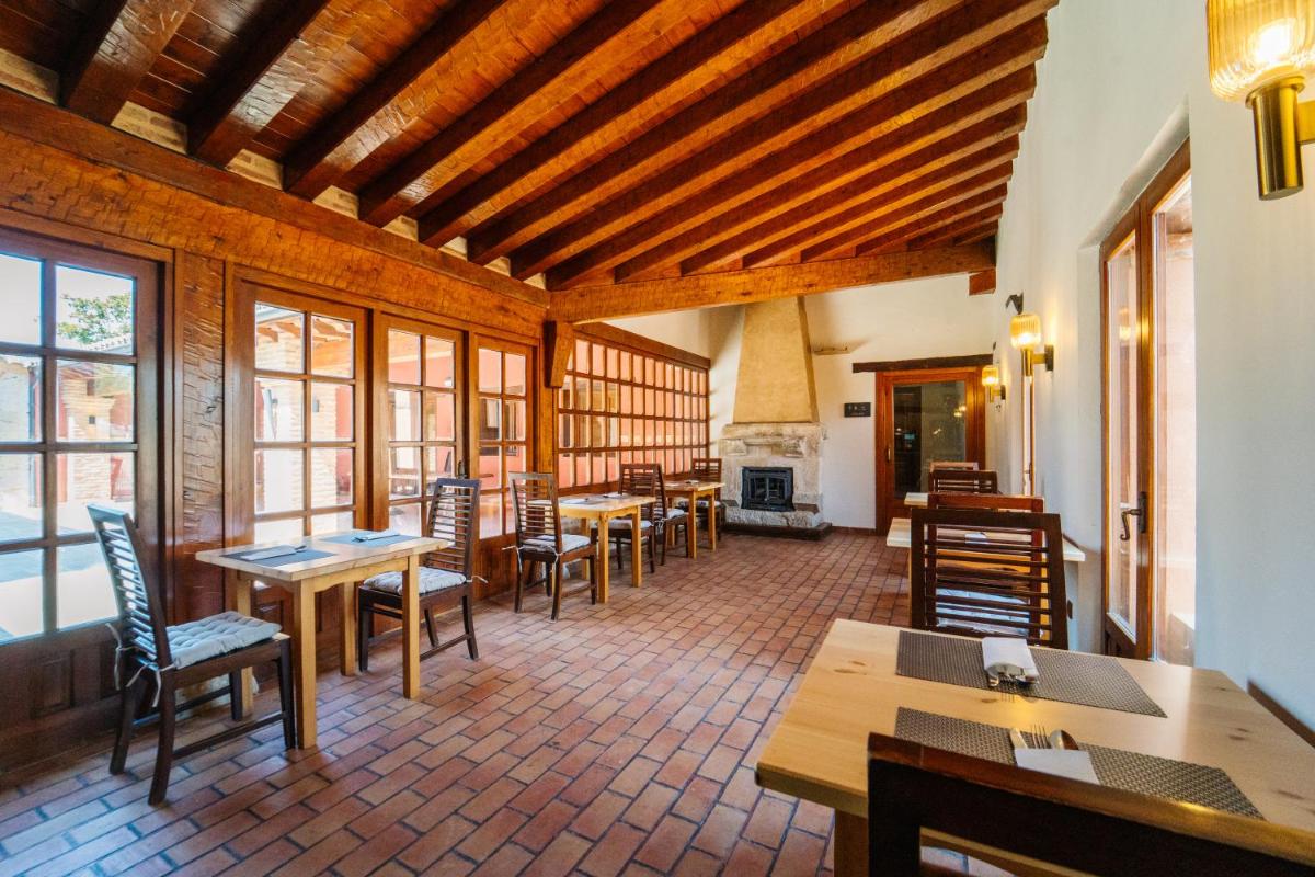 Un restaurante con mesas y sillas y chimenea. en Abba las Viñas Tiedra, en Tiedra