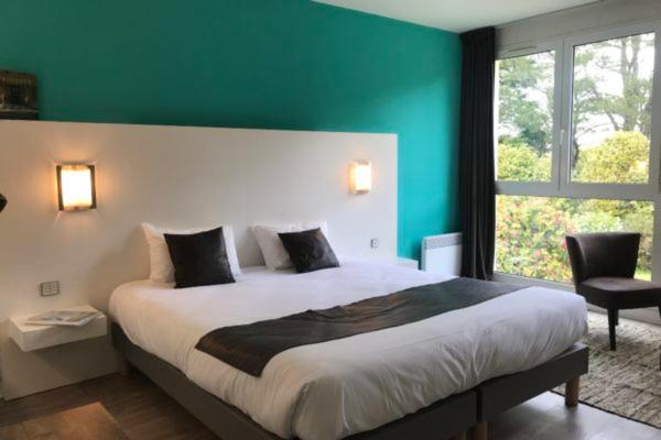 Un ou plusieurs lits dans un hébergement de l'établissement Logis Latitude Ouest Hôtel Restaurant & Spa