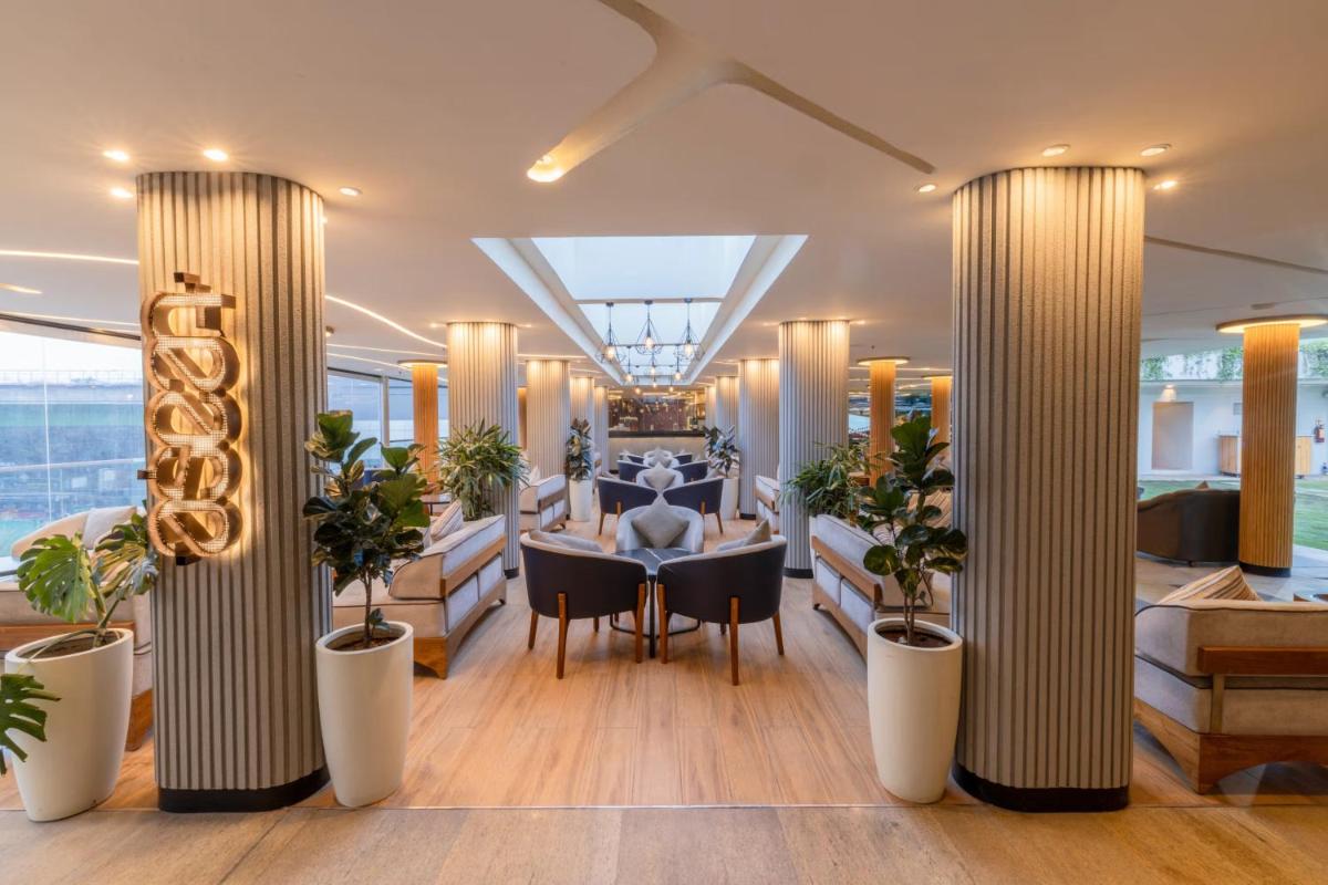 a dining room on a yacht with potted plants at Vivanta Bengaluru, Whitefield in Bengaluru