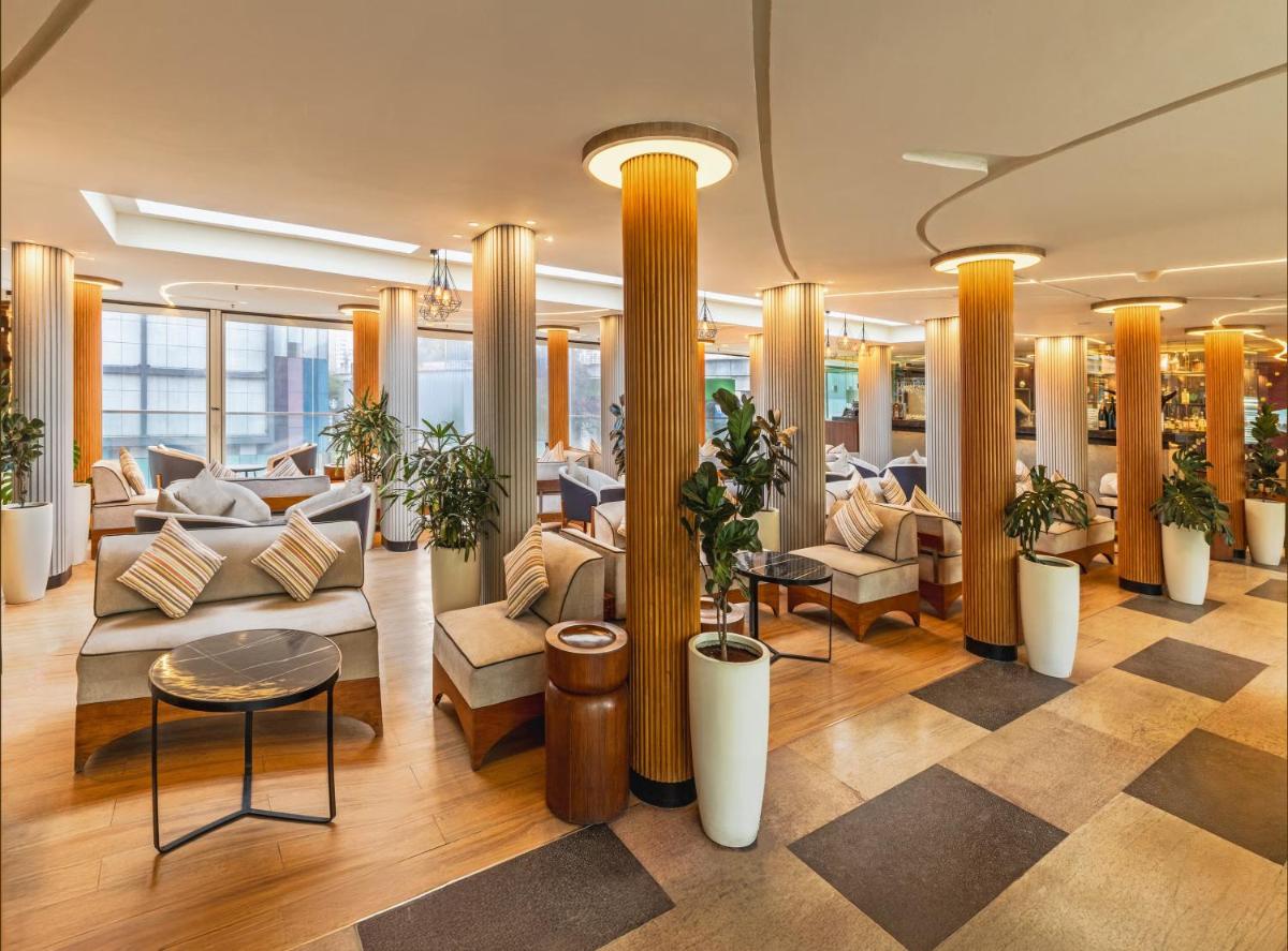 a lobby on a cruise ship with couches and plants at Vivanta Bengaluru, Whitefield in Bengaluru