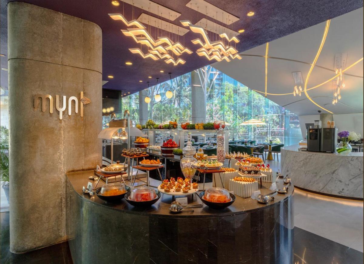 a buffet in a building with food on a table at Vivanta Bengaluru, Whitefield in Bengaluru