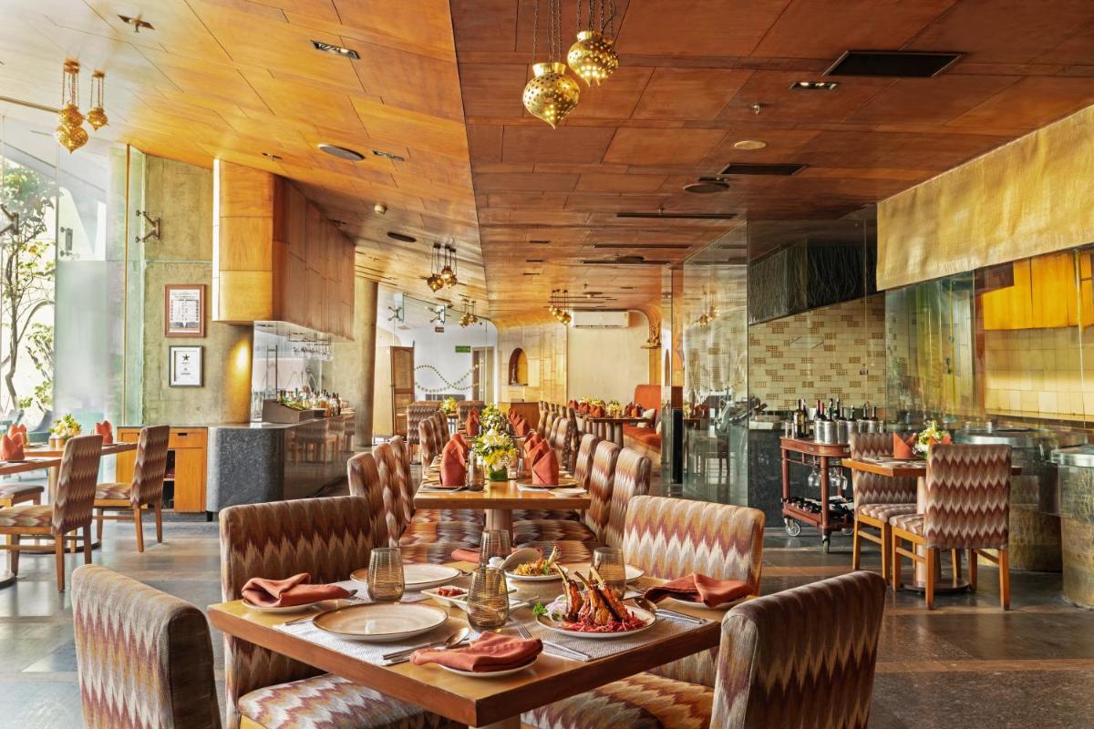 a dining room with a table and chairs at Vivanta Bengaluru, Whitefield in Bengaluru