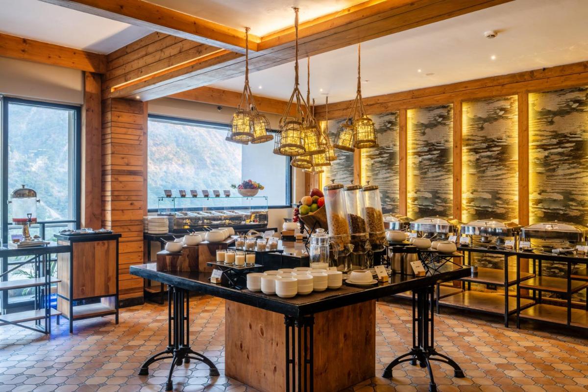 a kitchen with a table with food on it at Antalya By Divine Ganga Cottage in Rishīkesh