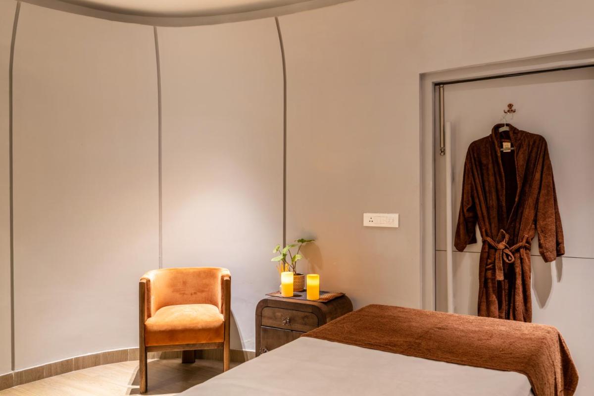 a room with a bed and a robe hanging on a door at Antalya By Divine Ganga Cottage in Rishīkesh