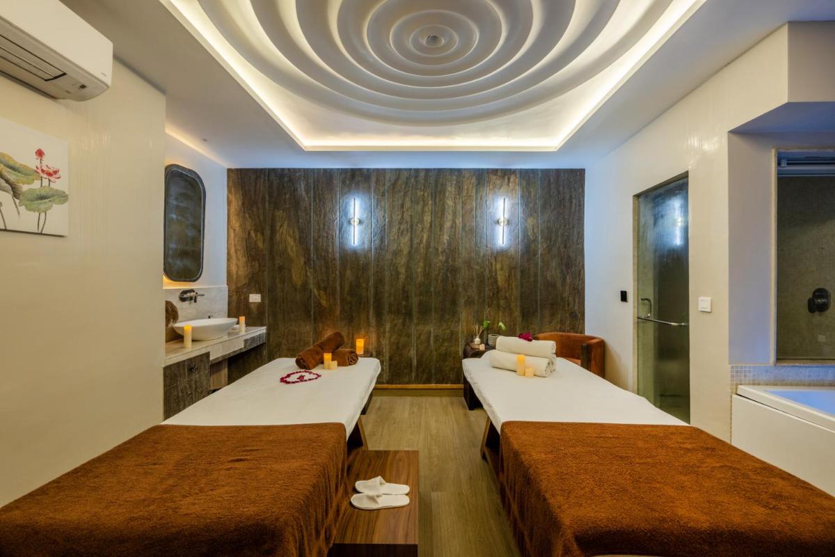 two beds in a hotel room with a ceiling at Antalya By Divine Ganga Cottage in Rishīkesh