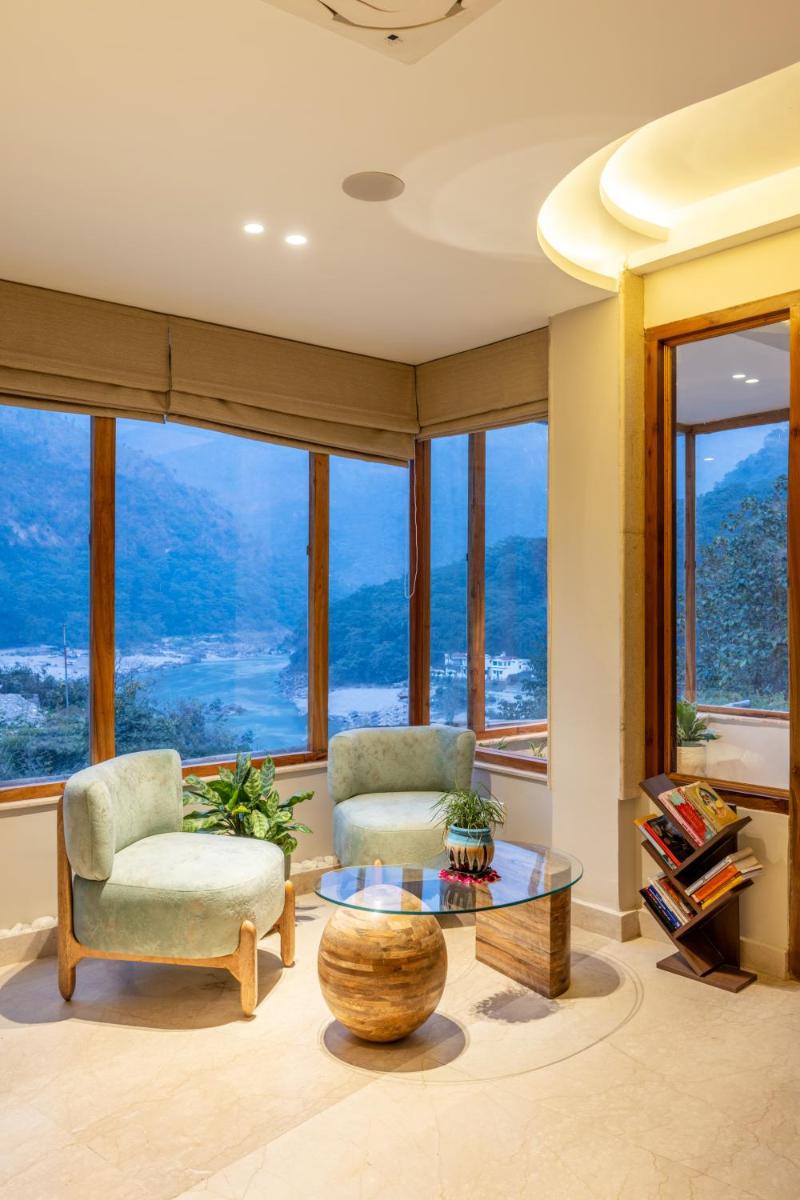 a living room with two chairs and a glass table at Antalya By Divine Ganga Cottage in Rishīkesh