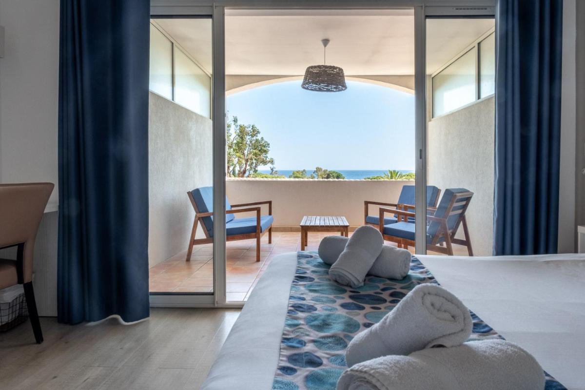 une chambre avec un lit avec vue sur l'océan dans l'établissement Hôtel Beau Site, au Lavandou