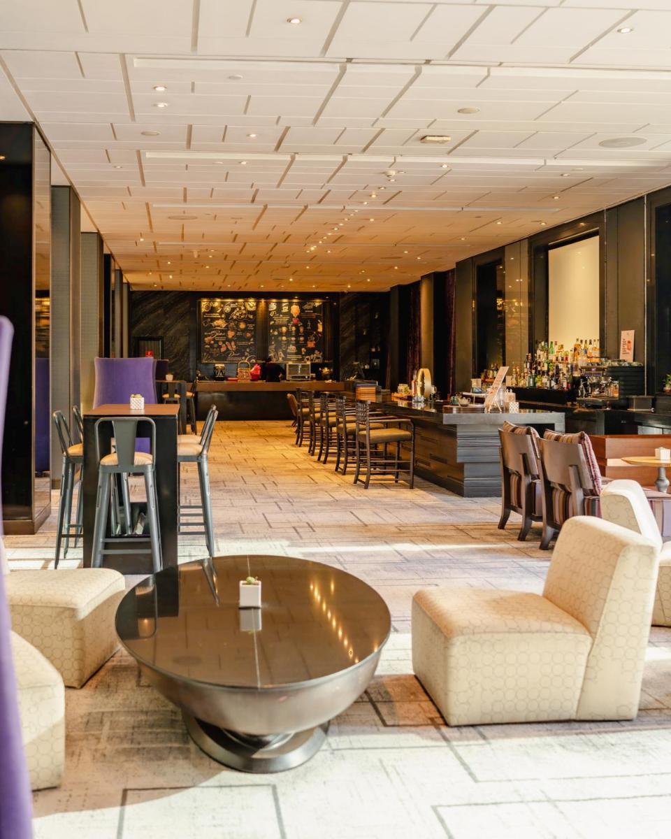 a lobby with a table and chairs and a bar at Hyatt Regency Gurgaon in Gurgaon