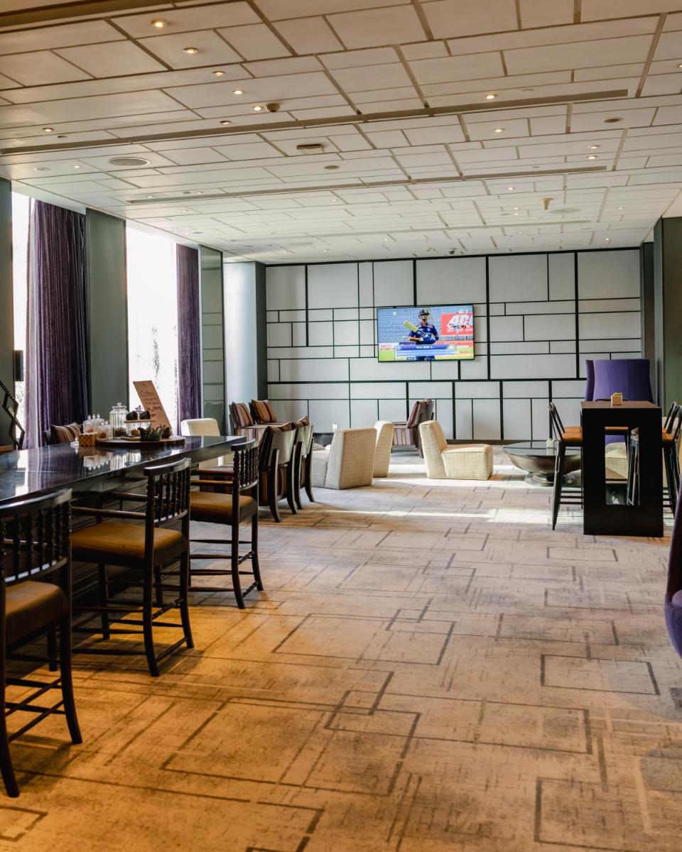 a large room with tables and chairs and a couch at Hyatt Regency Gurgaon in Gurgaon