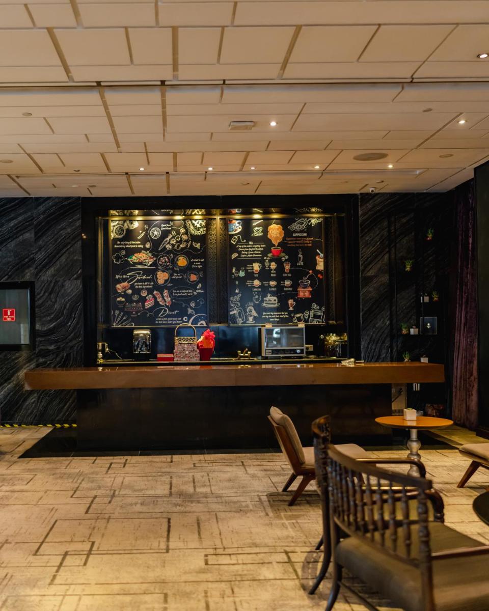 a bar in a restaurant with a table and chairs at Hyatt Regency Gurgaon in Gurgaon