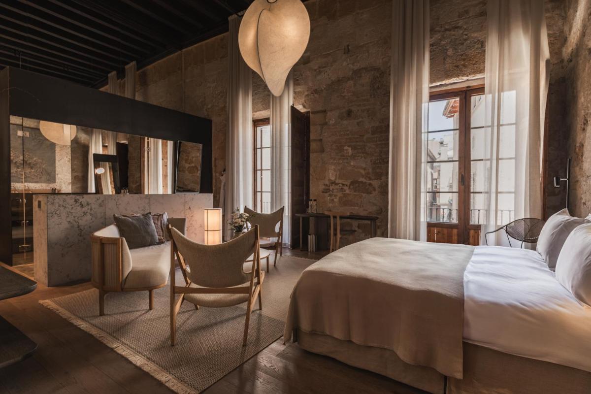 1 dormitorio con cama, sillas y mesa en Nobis Hotel Palma, a Member of Design Hotels, en Palma de Mallorca 84 fotos más