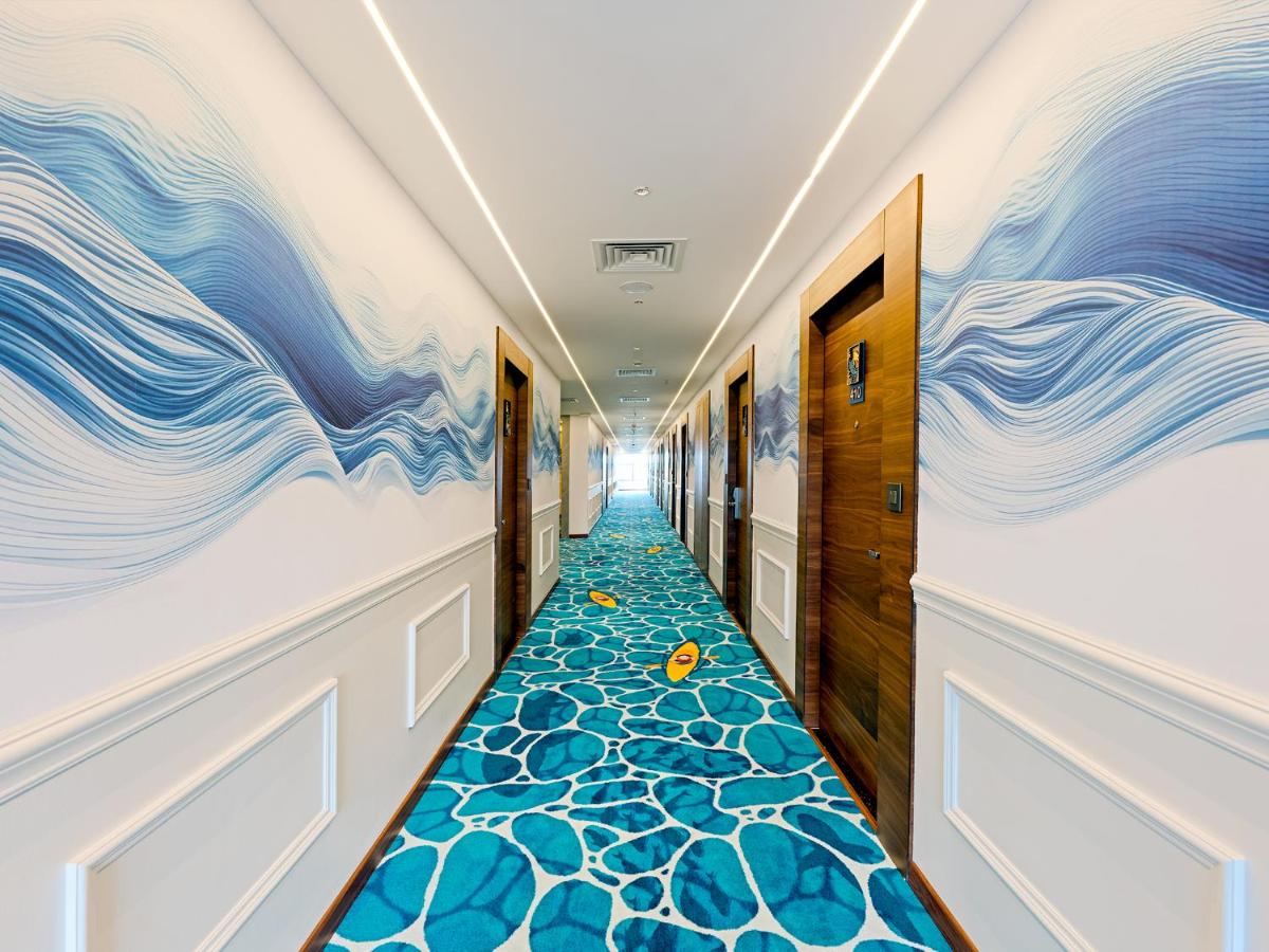 a hallway with blue waves painted on the walls at Gateway Goa, Palolem in Palolem