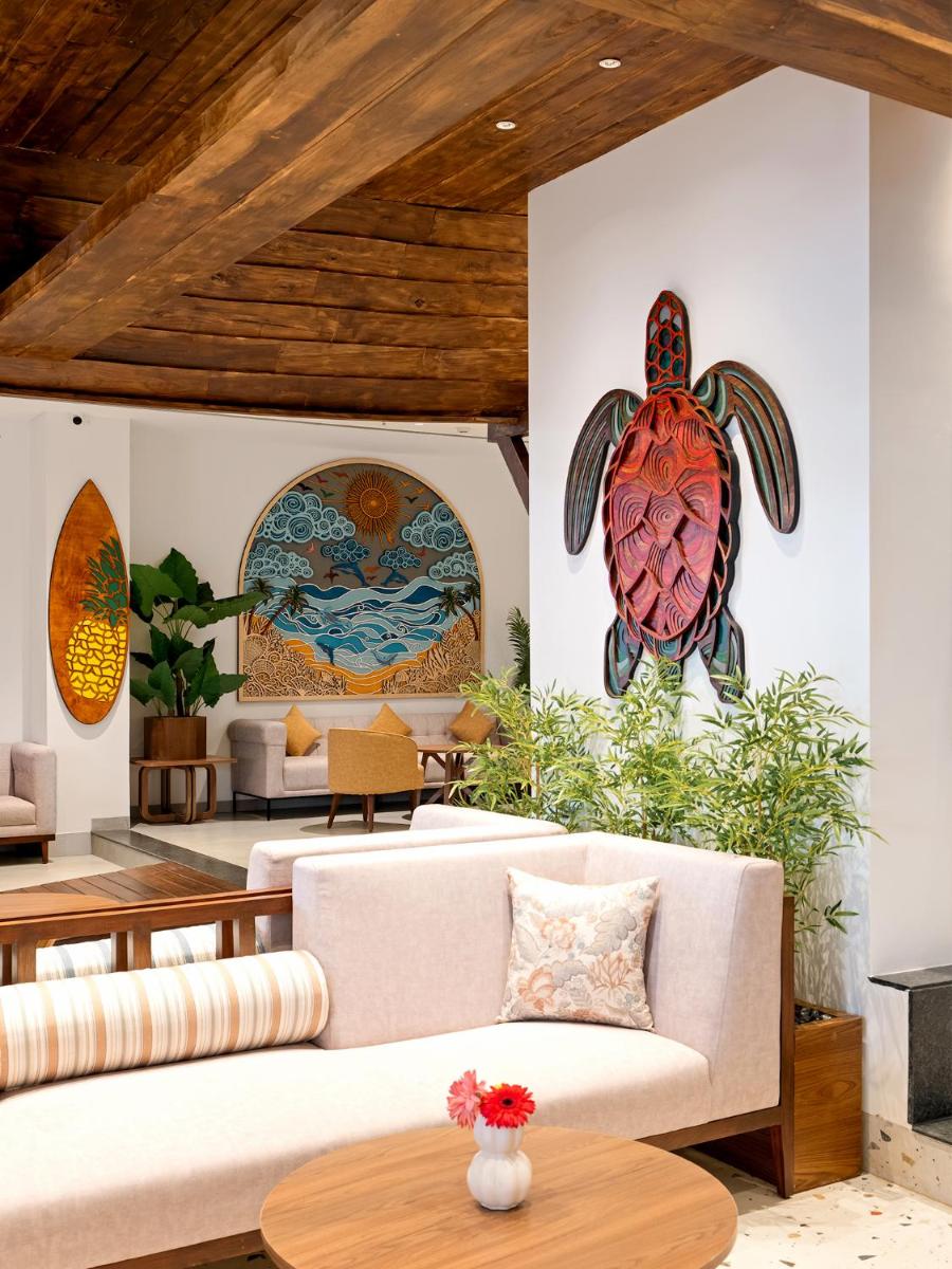 a living room with a couch and a turtle painting on the wall at Gateway Goa, Palolem in Palolem