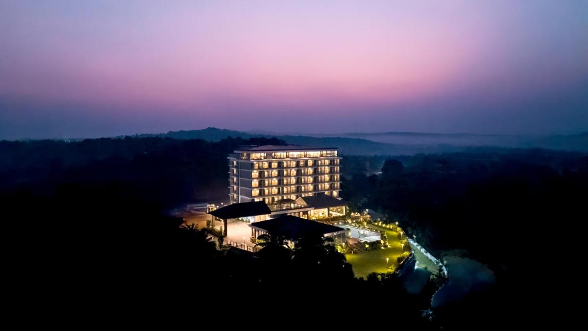 a tall building at night with the lights on at Gateway Goa, Palolem in Palolem