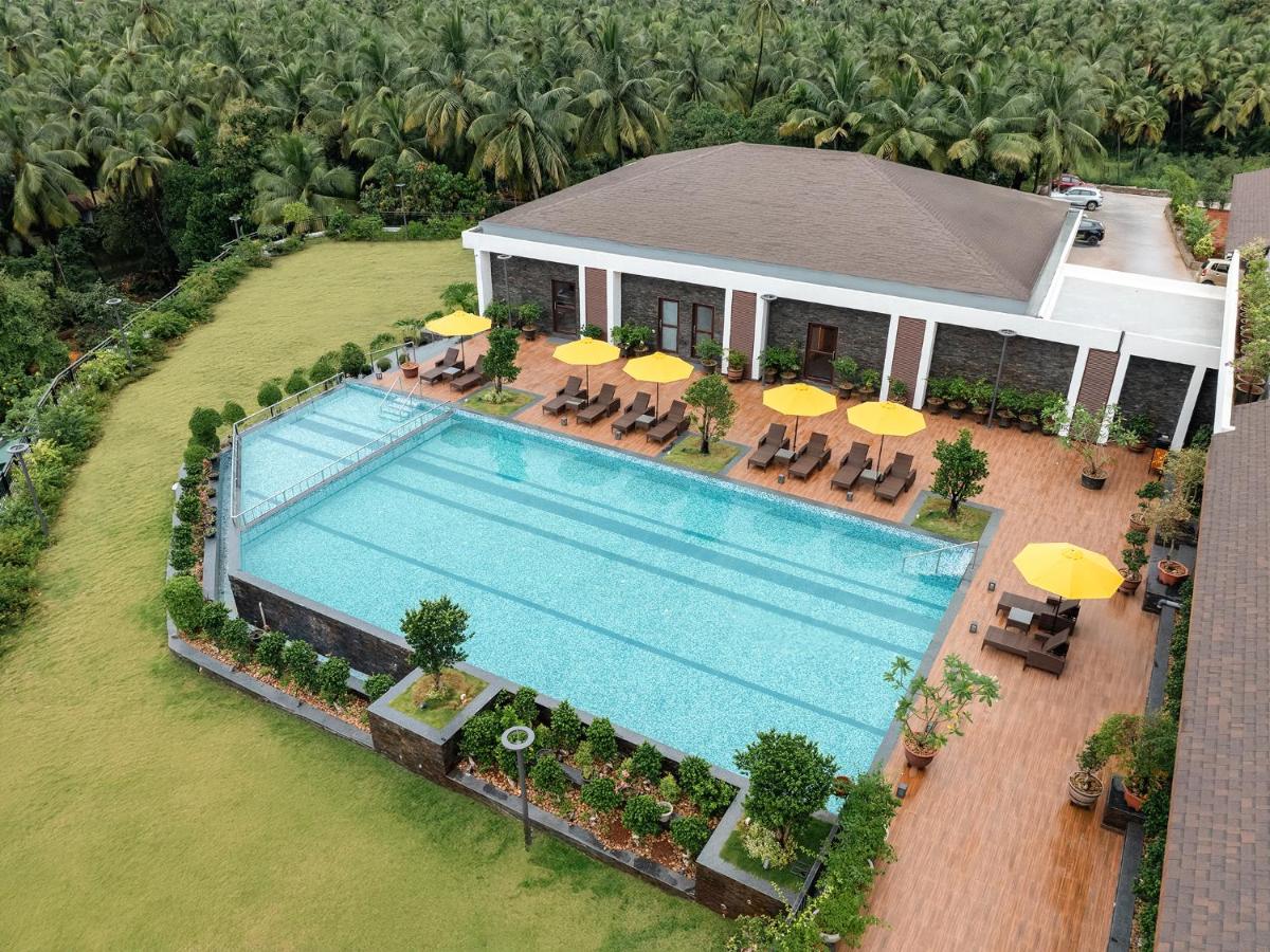 an overhead view of a swimming pool with chairs and umbrellas at Gateway Goa, Palolem in Palolem