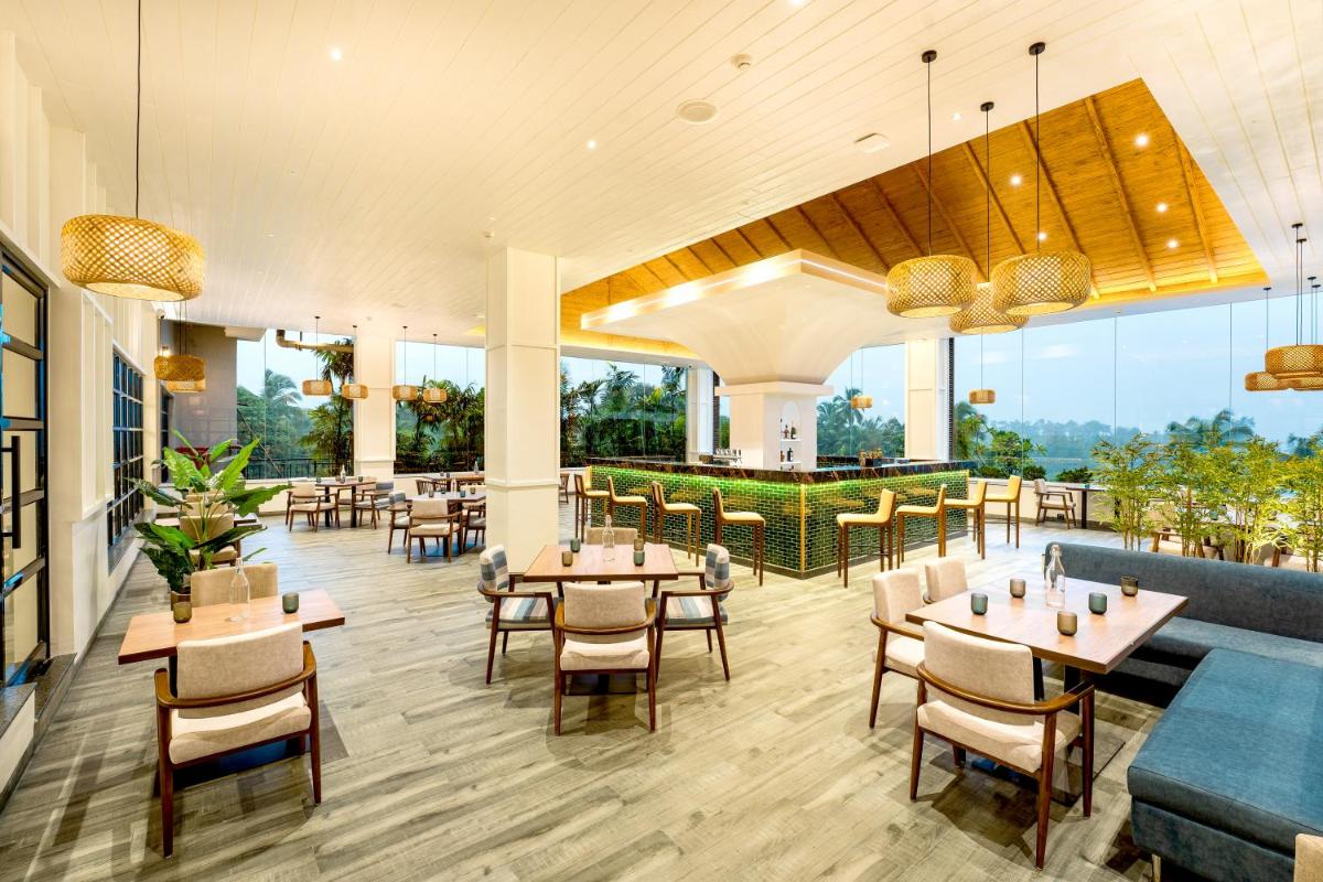 a restaurant with tables and chairs and windows at Gateway Goa, Palolem in Palolem