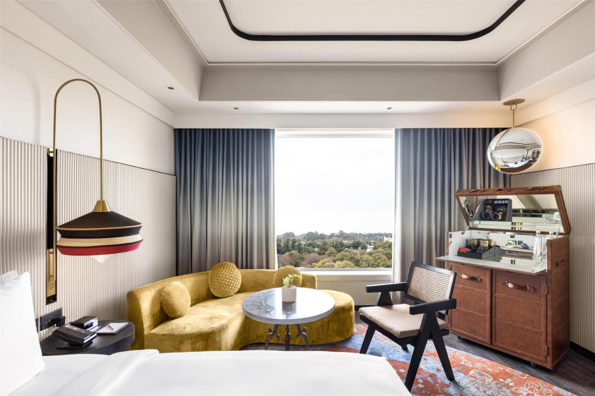 a hotel room with a bed and a couch and a table at Hyatt Centric Sector17 Chandigarh in Chandīgarh