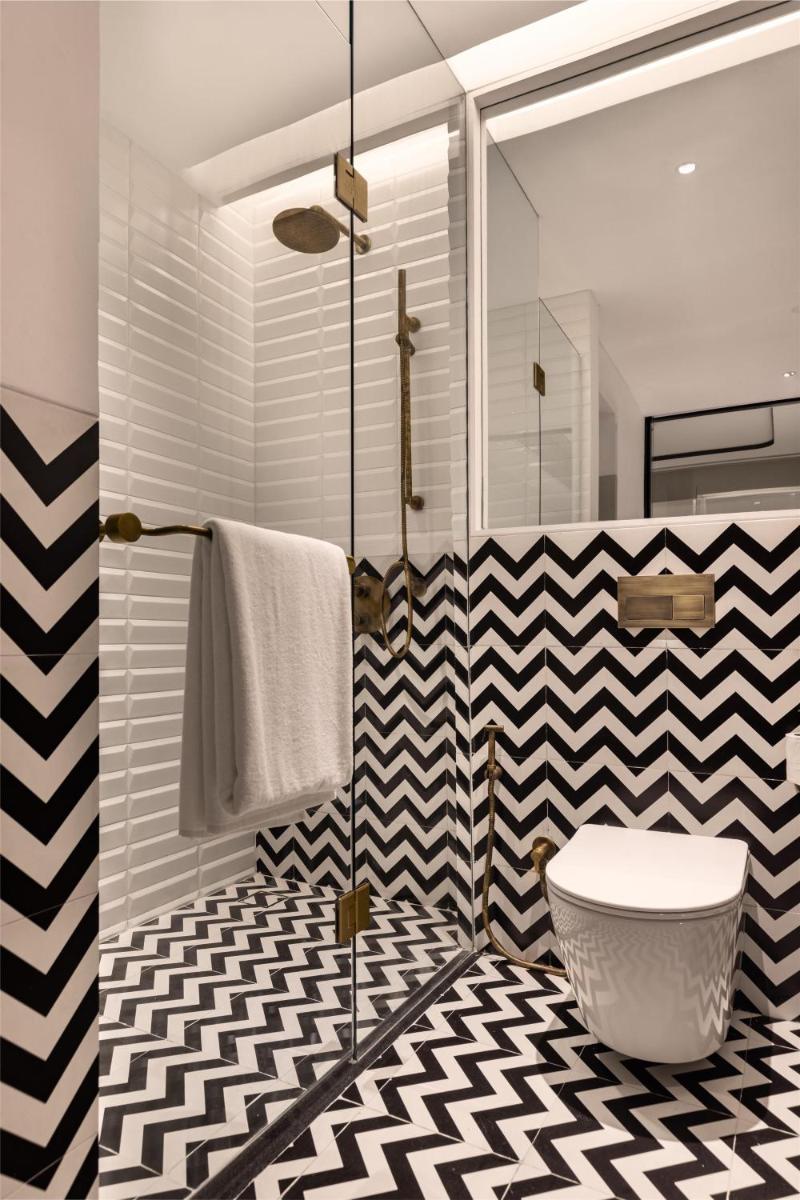 a bathroom with a black and white checkered floor at Hyatt Centric Sector17 Chandigarh in Chandīgarh