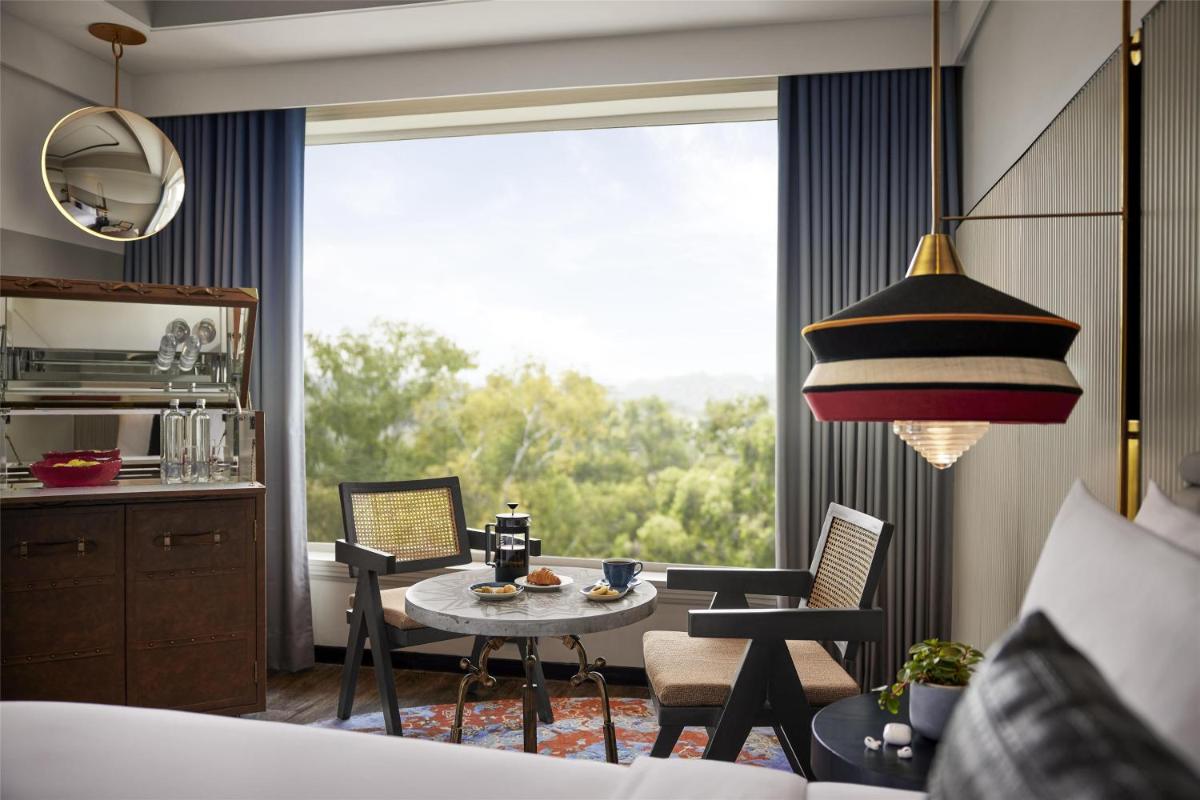 a living room with a table and chairs and a large window at Hyatt Centric Sector17 Chandigarh in Chandīgarh