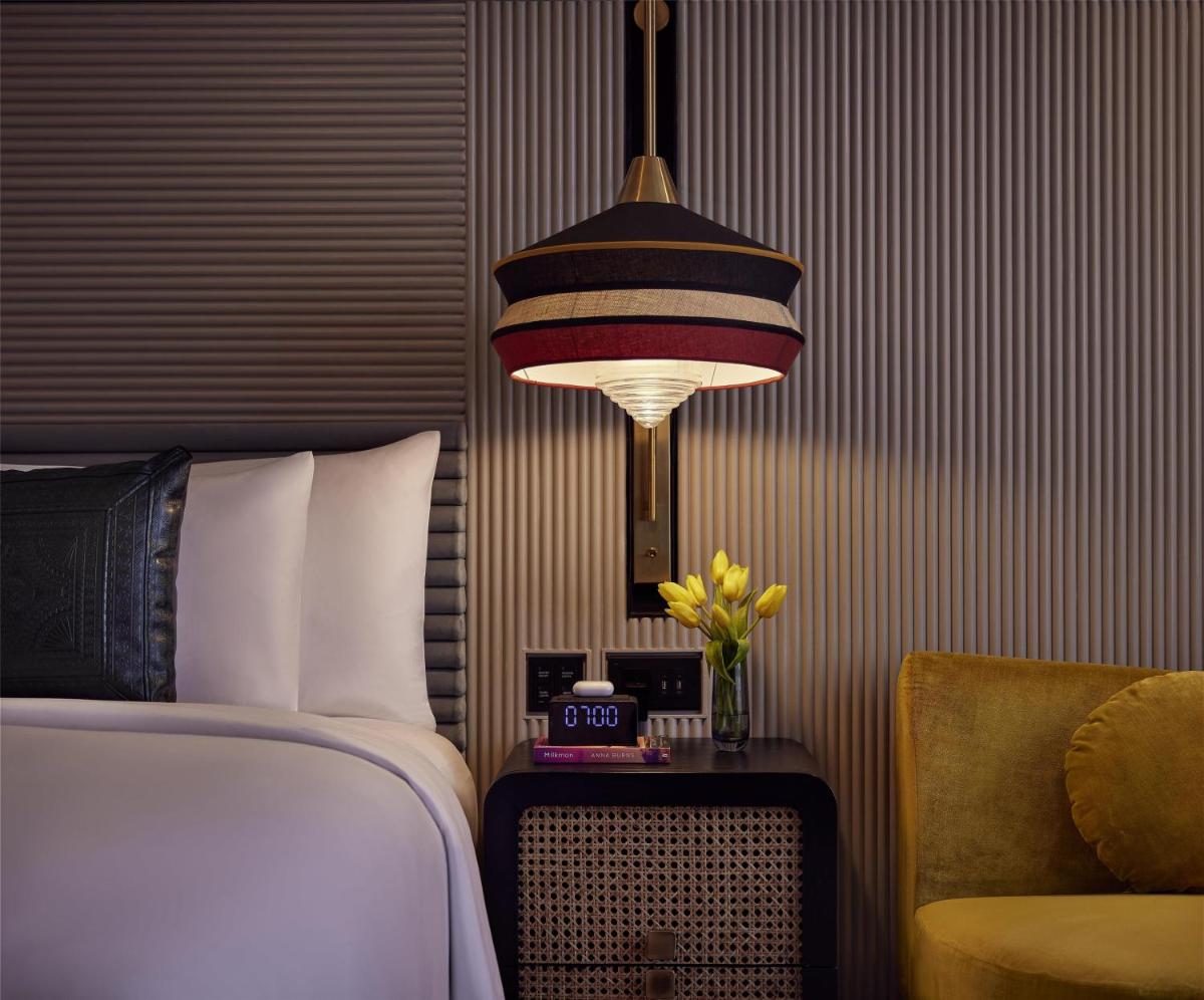 a bedroom with a bed and a lamp and a chair at Hyatt Centric Sector17 Chandigarh in Chandīgarh