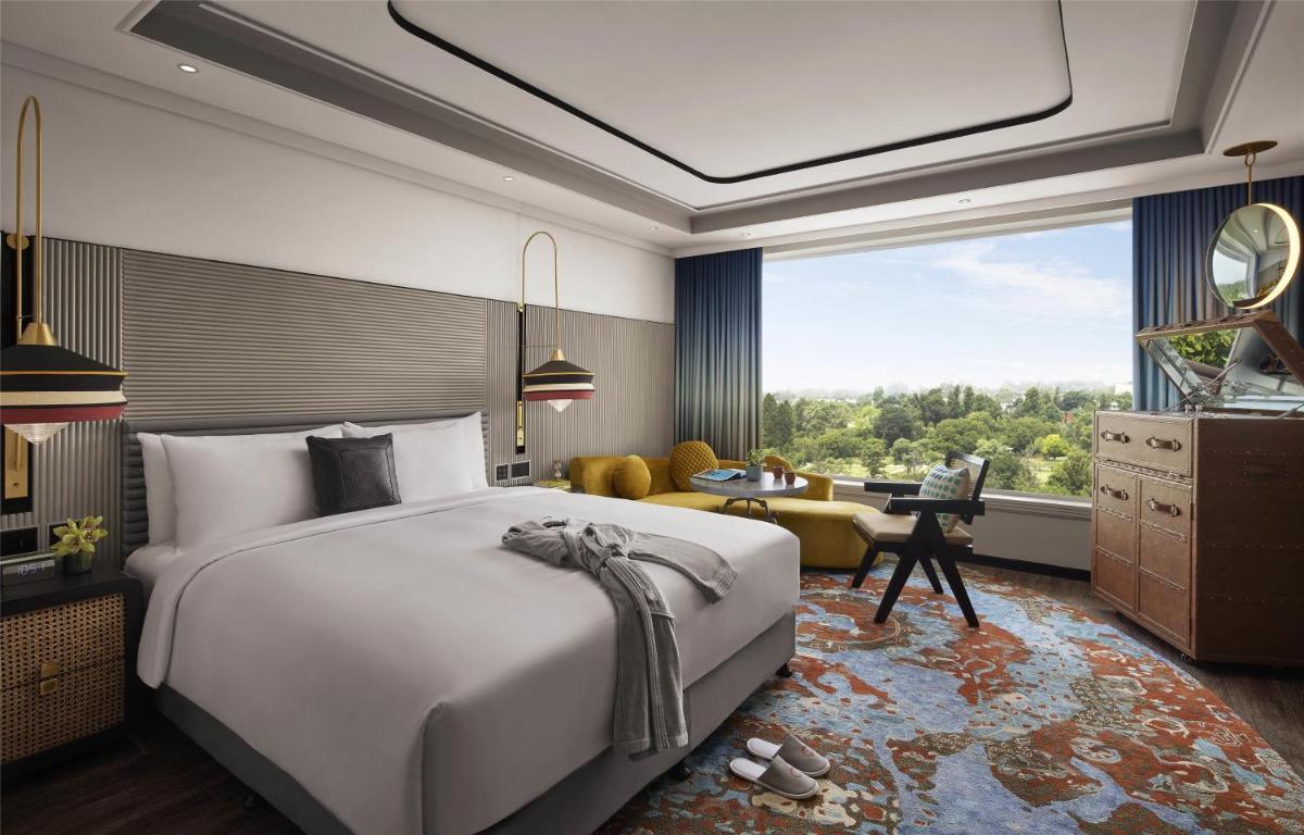 a bedroom with a large bed and a living room at Hyatt Centric Sector17 Chandigarh in Chandīgarh