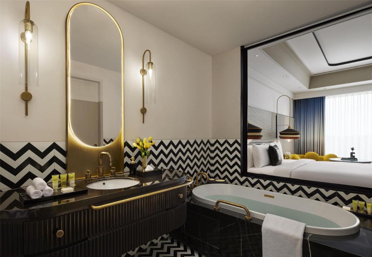 a bathroom with a tub and a sink and a bed at Hyatt Centric Sector17 Chandigarh in Chandīgarh