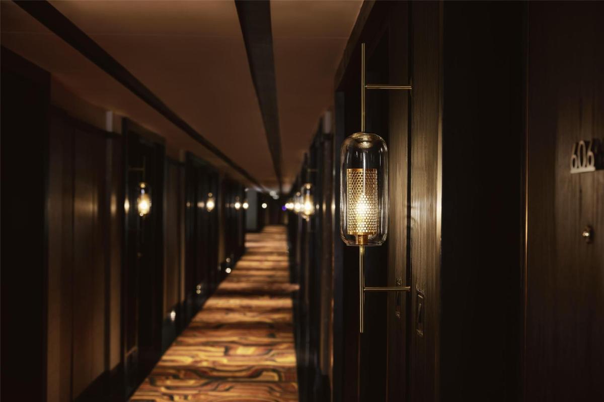 a hallway with a row of doors and a light fixture at Hyatt Centric Sector17 Chandigarh in Chandīgarh