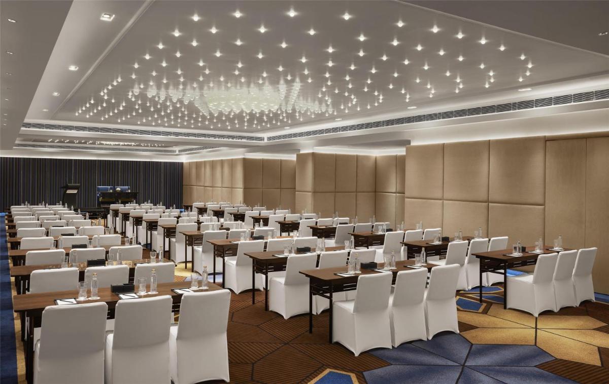 a large banquet hall with tables and white chairs at Hyatt Centric Sector17 Chandigarh in Chandīgarh